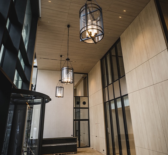 Hall d’entrée en double hauteur avec menuiseries acier et suspensions.