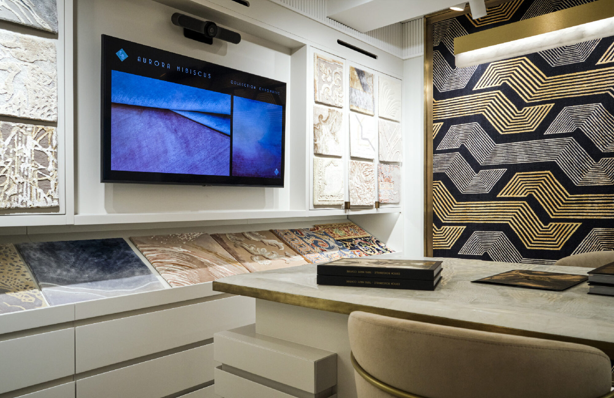 Matériauthèque du showroom : échantillons de tapis et écran de présentation.